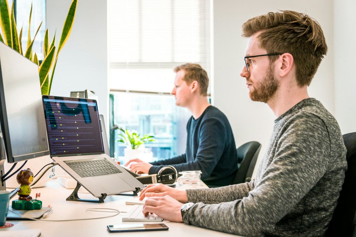 Support engineers working at monitors in an operations office